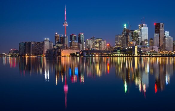 The Toronto skyline at night, reflected in Lake Ontario.