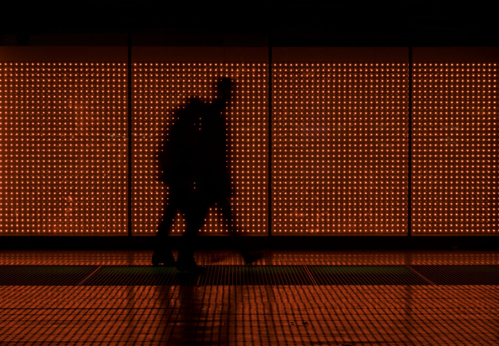 Silhouette of two people moving in red background